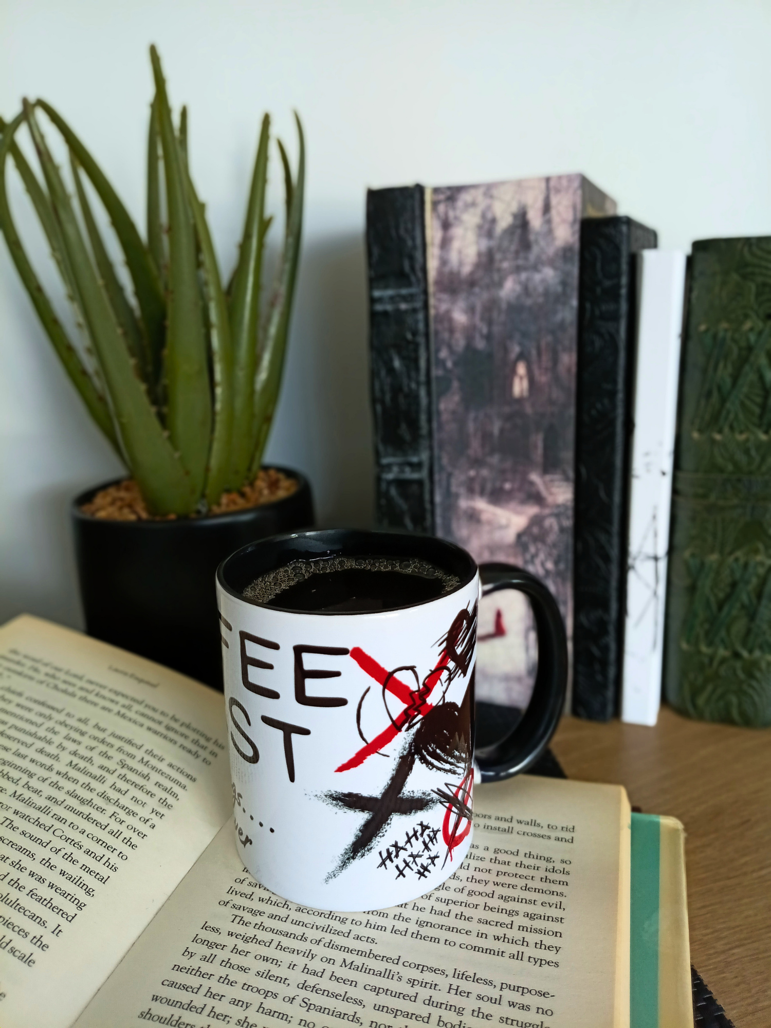 Mug with a red cross over the word 'Free' on an open book with a plant and books in the background.