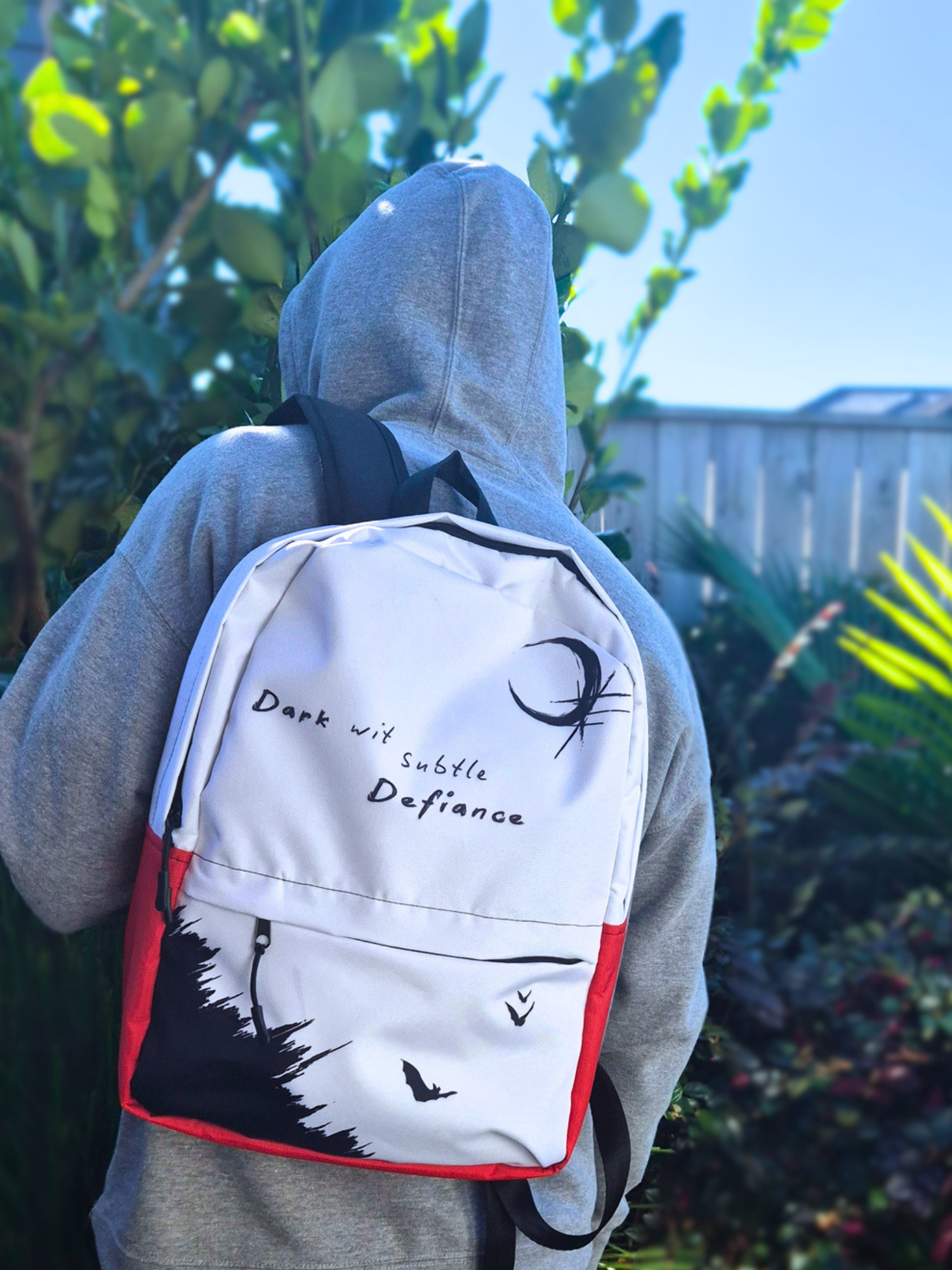 Person wearing a gray hoodie with a white backpack featuring black text and graphics.